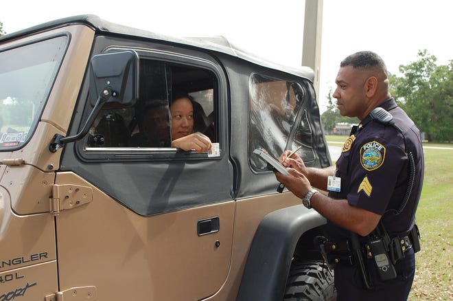 Patrolman Stephen Parker of the NAS Jax Security Department stops a vehicle to check for seat belt usage. During the annual Click It or Ticket Campaign, tickets will be issued for those not using their seatbelts as required by Florida law.