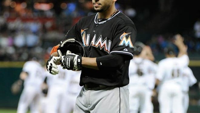 Miami Marlins' Omar Infante walks off the field as the Houston Astros celebrate their 3-2 win.