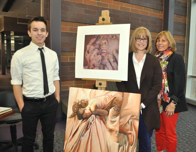 Jesse Clevenger (left), was honored at the Jackson Schools Board of Education meeting. Standing next to a few pieces of his award winning artwork are Debbie Tisdale, art teacher, and Susan Gardner, coordinator for special programs.