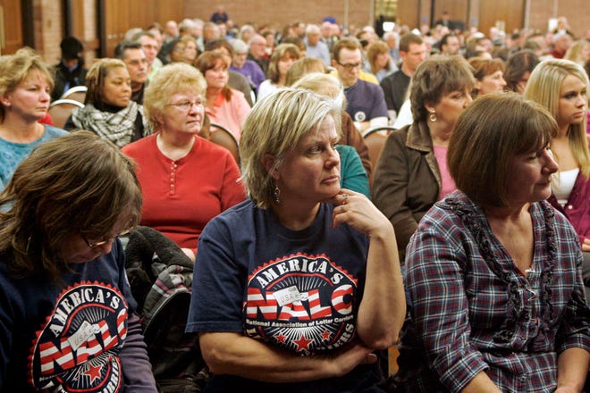 Postal carriers (front from left) Mary Slowik, Robin Maurer and Mary Ann Myers listen as Victor Dubina, U.S. Postal Service Great Lakes Area manager of corporate communications, speaks during a meeting by the U.S. Postal Service on the proposed closing of the Rockford mail processing and distribution center Thursday, Jan. 5, 2012, at the Clock Tower in Rockford.