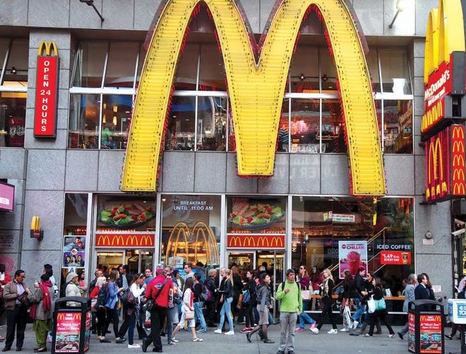 People walk near a McDonald's restaurant in New York's Time Square. April sales growth fell below the worldwide chain's goal.