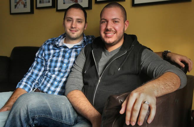 Coty (left) and Shane May at their home on Wednesday in Cuyahoga Falls. The couple, who were married in Washington, D.C., was told by the Cuyahoga Falls law director that Ohio does not recognized gay marriage so they couldn't get a married couple's pass at the Cuyahoga Falls natatorium. (Ed Suba Jr./Akron Beacon Journal)
