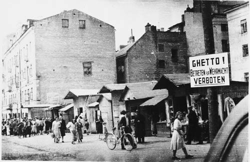 AP Photo/United States Holocaust Memorial Museum - In this circa 1941-1942 photo provided by the United States Holocaust Memorial Museum, people walk on a commercial street in the Lublin ghetto near a sign forbidding entry, in Warsaw, Poland.