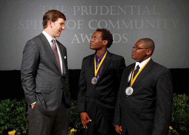 New York Giants quarterback and 2012 Super Bowl MVP Eli Manning congratulates Kenneth Smalls-Muldrow, 18, of Pooler (center) and Rashad Holmes, 13, of Rockdale (right) on being named Georgia's top two youth volunteers for 2012 by The Prudential Spirit of Community Awards.