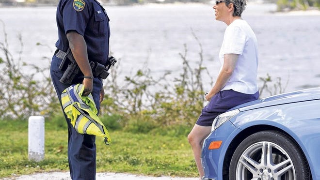 Palm Beach police officer Daniel Wilkinson talks to a driver at the scene of the accident.