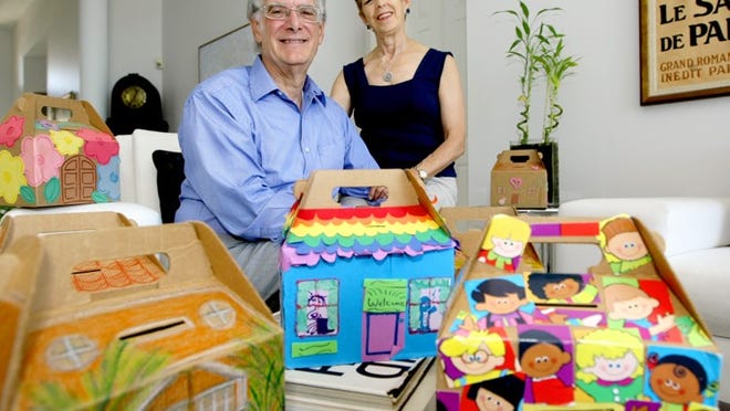 Mark Wasserman and his wife, Sue Gurland, with several of the collections boxes decorated by area children at home in Boca Raton.