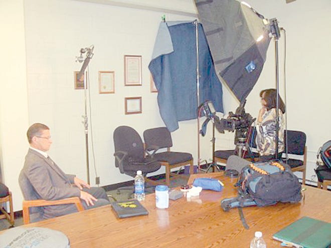 Michigan State Police Detective Sgt. Michael Morey, seated, waits Friday to rehash unfolding of an investigation leading to the arrest and conviction of the person responsible for 2006 murder of a Hubbardston woman. Patricia Bates of Charlotte, N.C., the freelance producer, stands behind the camera, preparing to interview Morey, who was the lead investigator on the case.