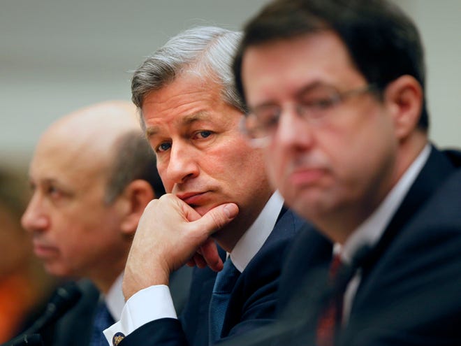 In this Feb. 11, 2009 file photo, JPMorgan Chase & Co. Chief Executive Officer Jamie Dimon, center, flanked by Goldman Sachs & Co. Chief Executive Officer and Chairman Lloyd C. Blankfein, left, and Bank of New York Mellon Chairman Chief Executive Officer Robert Kelly, are seen on Capitol Hill in Washington during a House Financial Services Committee hearing. Dimon had to face stock analysts and reporters on Thursday, May 10, 2012, and confess to a “flawed, complex, poorly reviewed, poorly executed and poorly monitored” trading strategy that lost a surprise $2 billion. (AP Photo/Lawrence Jackson, File)