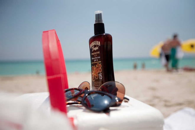 This Wednesday, May 9, 2012. file photo shows a bottle of sun tan lotion and sunglasses on top of a cooler carried onto Miami Beach, Fla. by tourists. Sunscreen confusion won't be over before summer after all. The government is bowing to industry requests for more time to make clear how much protection their lotions really offer.