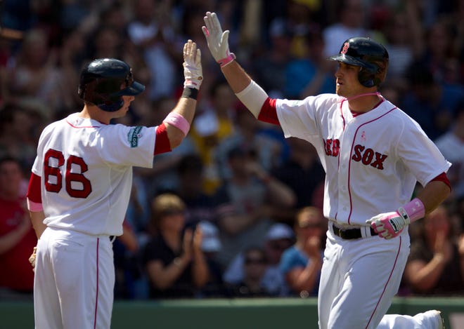 Boston Red Sox's Will Middlebrooks, right, is welcomed to home plate by teammate Daniel Nava after hitting a home run in the third inning of a baseball game at Fenway Park in Boston, Sunday, May 13, 2012.