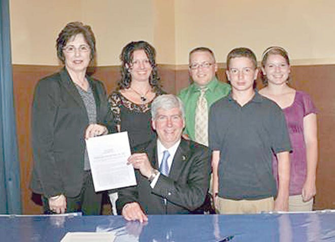 Sen. Judy Emmons, R-Sheridan, and Randy Hodge (center back) and his family join Gov. Rick Snyder as he signs Emmons’ four-bill package expanding opportunities for high school freshmen and sophomores and non-public students. The new laws enable students to take public community college or university courses for credit toward both a high school diploma and college degree. Hodge is the school administrator for St. Patrick Catholic School in Portland, Michigan.