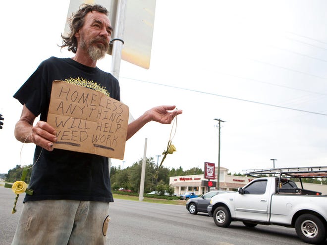 In this Sept. 9, 2011 file photo, Robert Munger panhandles at the corner of Northwest 35th Street and North U.S. 441. The Ocala City Council voted Tuesday not to make changes to its panhandling ordinance.