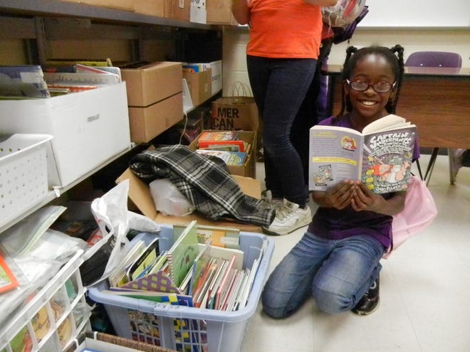Belden Elementary School student Janae Seawright holds a book donated by the Canton Rotary Club.