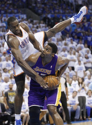 Oklahoma City Thunder forward Serge Ibaka (left) tumbles over Los Angeles Lakers center Andrew Bynum during the first quarter of Game 2 in an NBA basketball playoffs Western Conference semi-final, in Oklahoma City on Wednesday. (AP Photo/Sue Ogrocki)