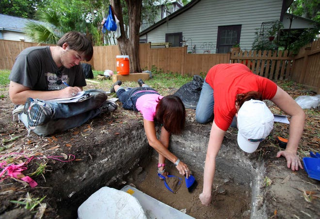 Volunteer Nick McAuliffe brushes debris away from from a spur that was found laying on top of a tabby floor covering dating to the early 1800's during the Flagler College Archaeology Program Field School on the corner of Spanish Street and Cuna Street on Wednesday, May 16, 2012.