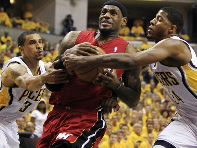 Miami Heat's LeBron James, center, goes to the basket against Indiana Pacers' George Hill (3) and Paul George, right, during the first half of Game 3 of their NBA basketball Eastern Conference semifinal playoff series, Thursday, May 17, 2012, in Indianapolis. (AP Photo/Darron Cummings)