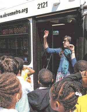 Jessica Dreschel, a communications specialist with Akron Metro, talks to Case Elementary School students during Big Truck Day at the school Thursday in Akron. Case students had the opportunity to see large working vehicles up close and learn their use from the vehicles' operators. (Karen Schiely/Akron Beacon Journal)