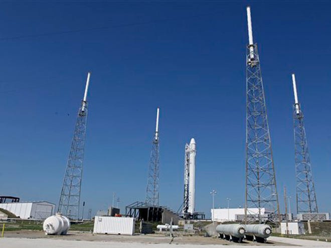 The Falcon 9 SpaceX rocket stands ready for launch at complex 40 at the Cape Canaveral Air Force Station in Cape Canaveral on Friday. The launch, scheduled for early Saturday morning will mark for the first time, a private company will send its own rocket to the orbiting International Space Station, delivering food and ushering in a new era in America's space program. (AP Photo/John Raoux)