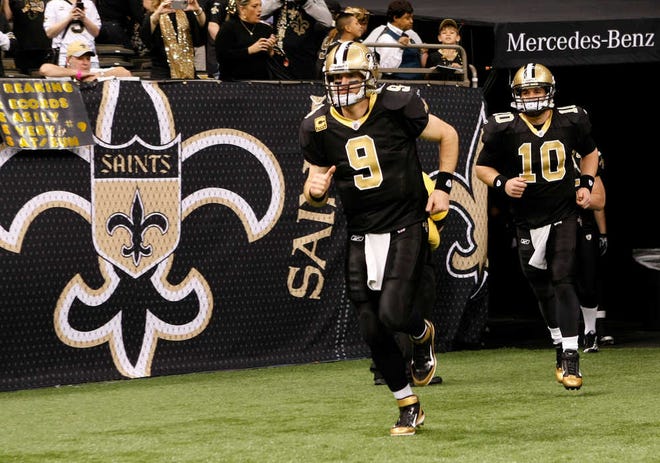 FILE - In this Jan. 7, 2012 file photo, New Orleans Saints quarterback Drew Brees (9) and quarterback Chase Daniel (10) run onto the field prior to the first half of an NFL wild card playoff football game against the Detroit Lions in New Orleans. With Brees staying away from Saints headquarters during protracted contract negotiations, Daniel has been penciled in to take the first-team snaps when New Orleans begins its first offseason practices next week. (AP Photo/Gerald Herbert, file)