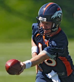 Denver Broncos quarterback Peyton Manning (18) hands the ball off during minicamp at the NFL team's football training facility in Englewood, Colo., on Monday, May 21, 2012. (AP Photo/Ed Andrieski)