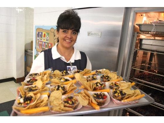 Ellie Beason holds a tray of nachos to be served at Washington Elementary School where she works as the school's cafeteria manager. During the summer, Beason also cooks for Camp Loy White and Carolina Cross Connection. (Ben Earp/The Star)