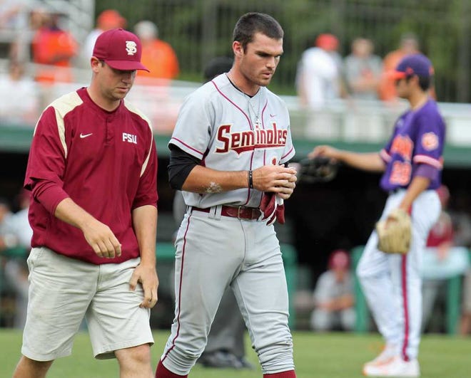 Florida State batter Jayce Boyd, center, walks to first base with trainer Cory Couture after getting hit in the helmet by Clemson pitcher Jonathan Meyer, right, in the second game of an NCAA college baseball doubleheader against Clemson on Monday, May 14, 2012 in Clemson, S.C. (AP Photo/Anderson Independent-Mail, Mark Crammer)