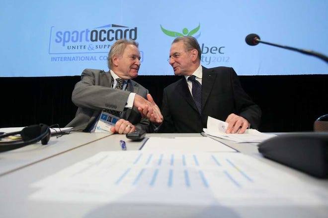 Denis Oswald, left, member of the International Olympic Committee executive board, and Jacques Rogge, president of IOC, shake hands before the beginning of a joint meeting of the IOC Executive Board and the Summer Olympic International Federation at the SportAccord conference in Quebec City Wednesday, May 23, 2012. SportAccord promotes communication and cooperation among various international sports federations. (AP Photo/The Canadian Press, Francis Vachon)