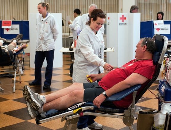 Dawn Hughes of the American Red Cross checks on blood donor Kinney Stegall while he makes a double red cells donation during an American Red Cross blood drive at First Methodist Church on Tuesday afternoon. According to a Red Cross official, demand for blood increases in the summer, which is the time of fewer donations, so there is a critical need for blood donors.