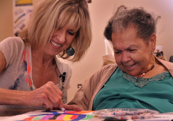The Healing Arts Program offers an art class for people struggling with mental illnesses at New Day Clubhouse. Sylvia Spears, left, works with 
Curtis Makupson on some art.