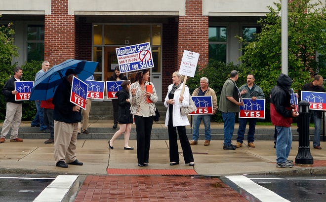 Protesters stand outside Natick Town Hall before last night’s public hearing on NStar and the Cape Wind project.