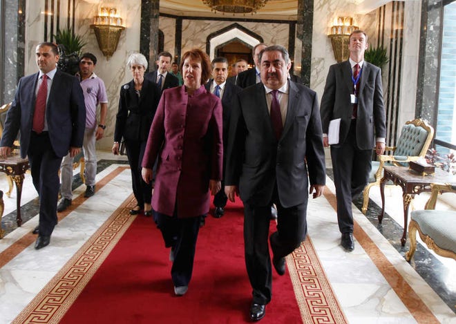 Iraq's Foreign Minister Hoshyar Zebari, second from right, walks Wednesday with the EU foreign policy chief Catherine Ashton upon her arrival at Baghdad International Airport in Iraq. Negotiators from the U.S. and five other world powers sat down with a team of Iranian diplomats to try to hammer out specific goals in the impasse over Tehran's nuclear program.