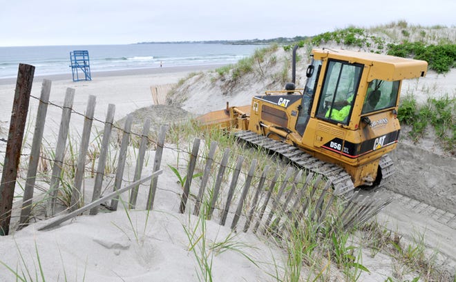 Middletown Parks and Recreation employee Mike Stahl bulldozes one of the paths at Sachuest Beach in preparation for opening day.