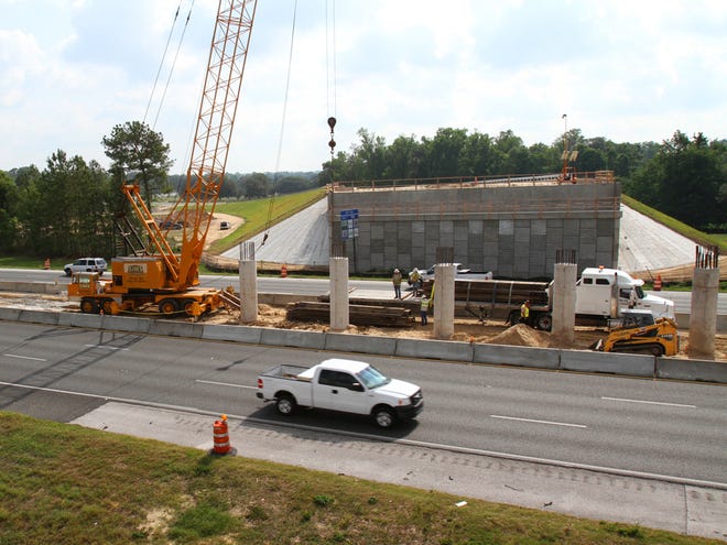 Workers move steel girders with a large crane in the median of I-75 where work continues on the Southwest 42nd Street flyover in Ocala, Fla. on Wednesday, May 23, 2012.