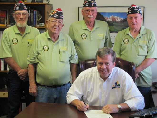 Canton Mayor Kevin Meade signs a proclamation marking Friday, May 25, and Saturday, May 26, as VFW Poppy Days, urging everyone to wear a Buddy Poppy as evidence of their gratitude for the sacrifices of U.S. armed forces personnel in defending our freedom. Looking on are (from left) William D. Ward, Jerry Foreman, Jim Guppy, and Gary A. Bouc of VFW Post 1984.