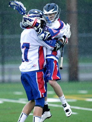 Ashland High’s DJ Miller, right, celebrates after scoring a goal last Tuesday night against Holliston, extending the Clockers’ lead to 6-4.