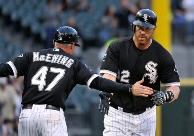 Chicago White Sox third base coach Joe McEwing (left) congratulates Adam Dunn who rounds third base after hitting a two-run home run, to also score Alejandro De Aza, during the first inning against the Cleveland Indians, Friday in Chicago. (AP Photo/Brian Kersey)