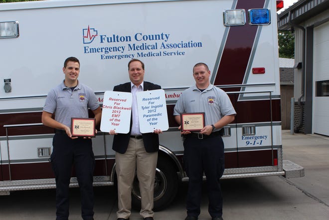 Tyler Ingold, 2012 Paramedic of the Year and Chris Blackwell, 2012 EMT of the Year are both members of the Fulton County Emergency Medical Association (FCEMA) and have been recognized for their performance, service and achievements. Above, Blackwell (at left) and Ingold (at right) receive plaques from Andrew Thornton, Executive Director of FCEMA. Thornton also holds signs which were created to designate their reserved parking spots at the facility.