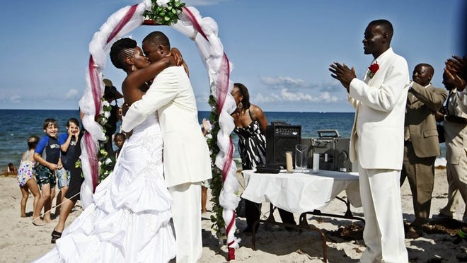 Ester Baptiste and TiMarc Pierre kiss during their Wedding on the Waterway at Oceanfront Park on Saturday. The couple won the wedding after entering an essay contest, sponsored by the city to showcase park improvements.