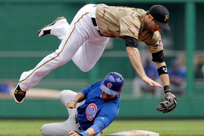 Chicago Cubs' David DeJesus, bottom, upends Pittsburgh Pirates second baseman Neil Walker to break up a double play on Cubs' Starlin Castro in the first inning of a baseball game in Pittsburgh, Sunday, May 27, 2012. (AP Photo/Gene J. Puskar)