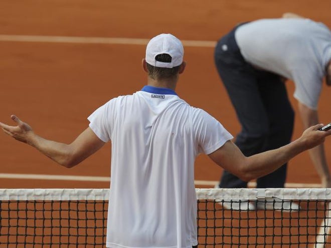 Andy Roddick of the U.S. argues a decision by referee Carlos Ramos of Portugal, rear, in his first round match against Nicolas Mahut of France at the French Open tennis tournament in Roland Garros stadium in Paris, Sunday May 27, 2012. Roddick lost to Mahut in four sets 6-3, 6-3, 4-6, 6-2.