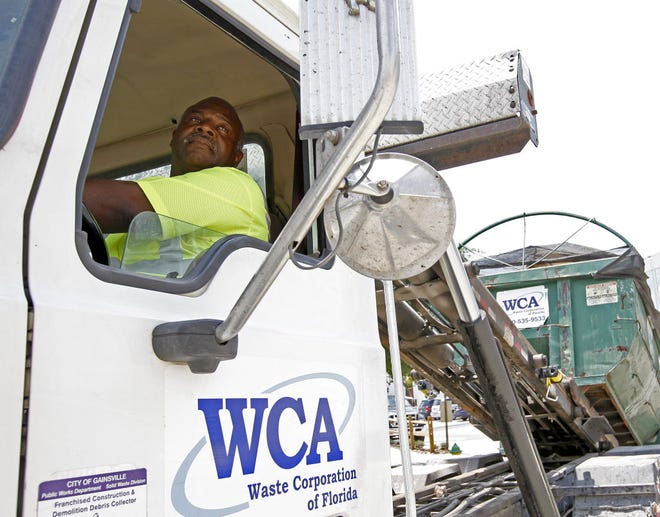 Steven Goodman looks in the mirror as he secures a load of garbage on Friday. Goodman was nominated for a national award by the Waste Corporation of America for his safe driving record.