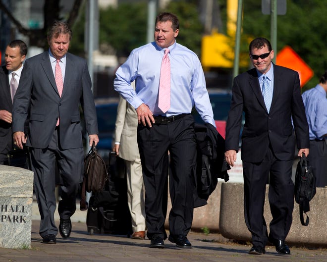 Roger Clemens, center, arrives at Federal court in Washington on Tuesday, accompanied by members of his legal team.