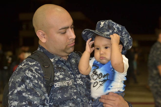 AT2 John Cervantes of VP-16 lets his son try on his cover after coming home from a six-month deployment.