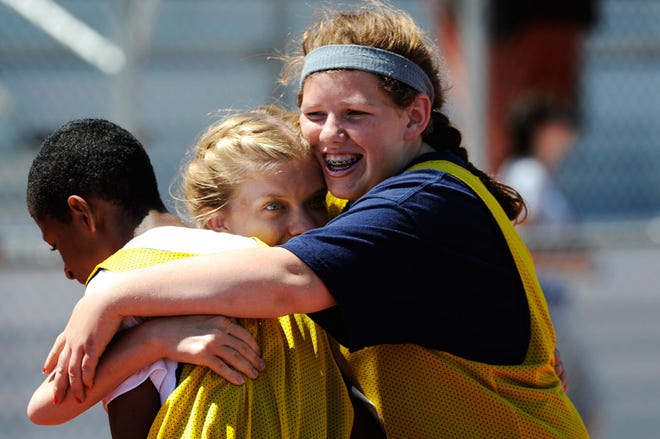 From left, Isaiah Young, Samantha Freeman and Sam Snow hug Wednesday after winning gold in the 100-meter relay in the Special Olympics State Summer Games at the University of Missouri. The team, which also included Ben Kettlewell, is from William Chrisman High School in Independence.