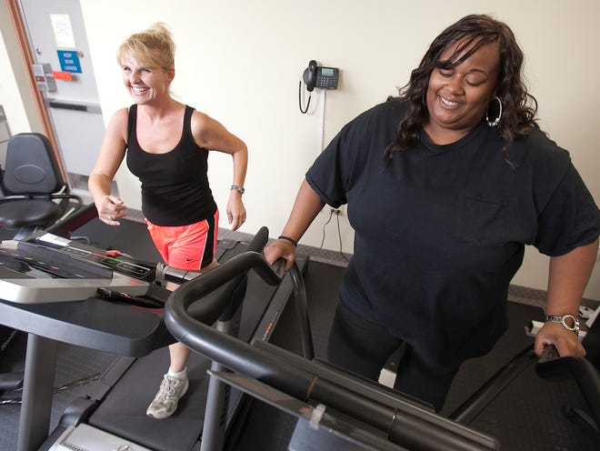 Heidi Beckius, left, supervisor of the Marion County Tax Collectors call center and Angela Brown, right, a call center employee, work out during their lunch period Wednesday afternoon, May 23, 2012 in the gym area at the tax collectors office. "I think promoting a healthy lifestyle is important," George Albright said. "Blue Cross Blue Shield purchased the (bicycle, treadmill and elliptical machine). Everybody else brought in the weights and the weight machine. No tax payers dollars were spent on this gym."