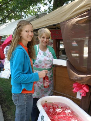 Pam Ricke, co-owner of The Vintage Button sells a bottle of some Rhu-berry soda to Emma VanVooren at this year's 2012 Rhubarb Festival.