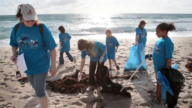 Michelle Bates (left) leads Loxahatchee Scouts in a Singer Island cleanup in 2010. The national group says it’s secular but embraces partnerships with religious groups.
