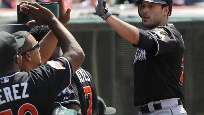 Greg Dobbs gets some love after scoring on a double by Marlins teammate Logan Morrison in the Marlins' 5-3 win over the Indians on Sunday, May 20, 2012, in Cleveland.