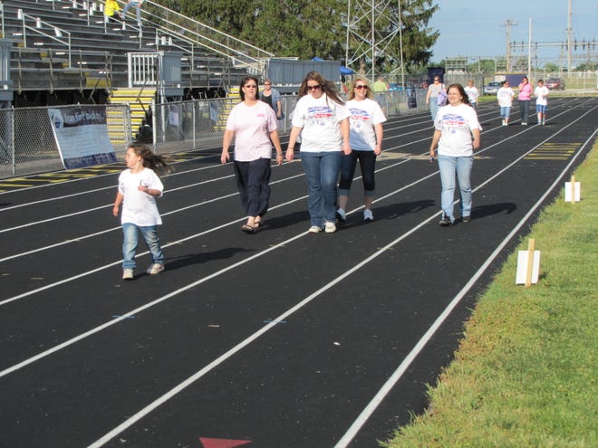 Participants in the 2012 Relay for Life step out on the track at Ron Fahnestock Field as they raise funds to help with cancer research and education. Teams collected pledges, as well as held raffles and sold snacks for donations to the American Cancer Society.