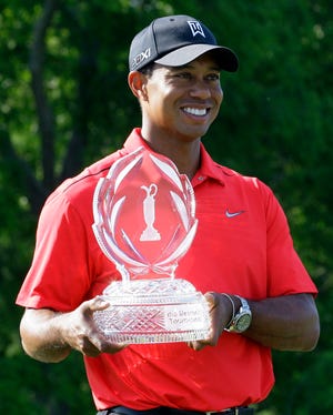 Tiger Woods holds up the trophy after winning the Memorial at the Muirfield Village Golf Club in Dublin, Ohio, on Sunday.